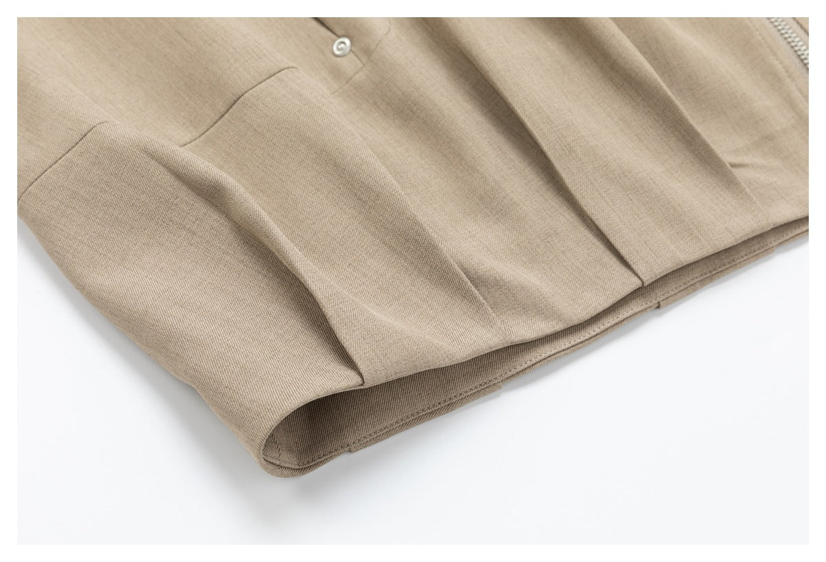 Close-up of the taupe jacket's lower hem and folded fabric seam.