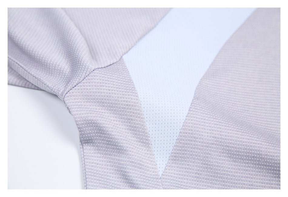 Close-up of a pale perforated V-shaped panel between textured gray-lilac shirt fabric sections.