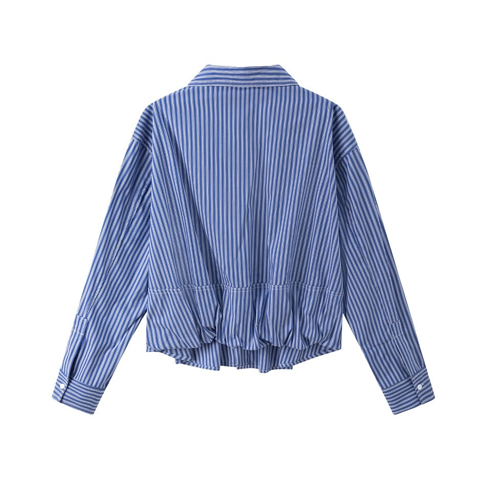 Back view of a blue and white pinstriped shirt laid flat, showing its gathered hem and long sleeves.