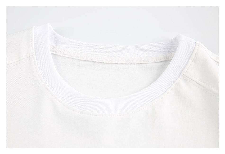 Close-up of a white shirt’s ribbed crew neckline and shoulder seams.