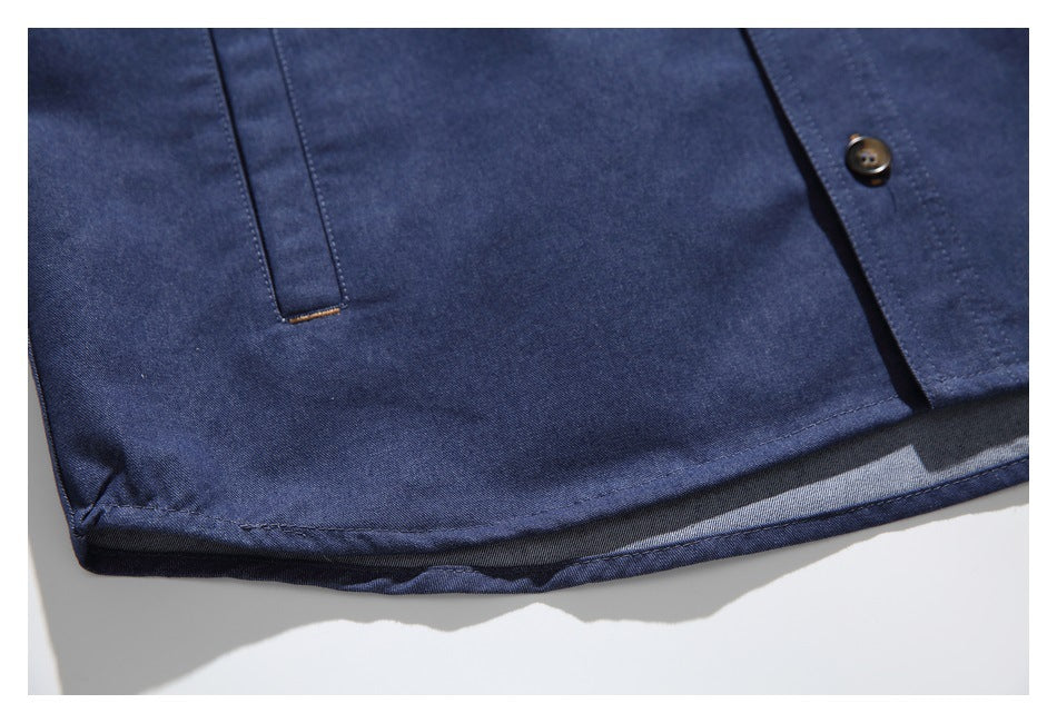 Close-up of the navy garment's lower front, showing a button placket, stitched detail, and curved hem.