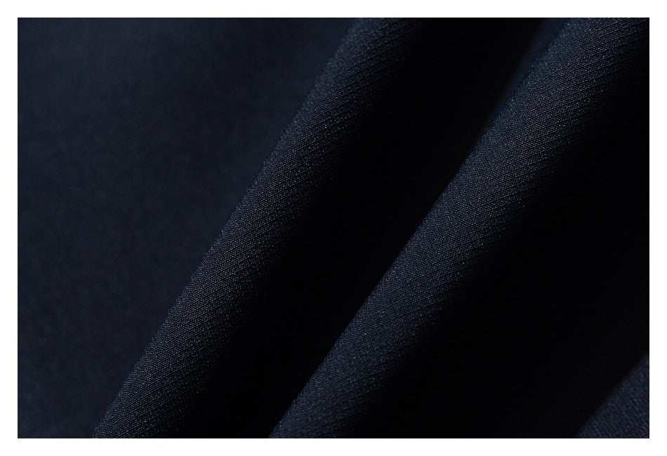 Extreme close-up of dark navy fabric folds and surface texture.