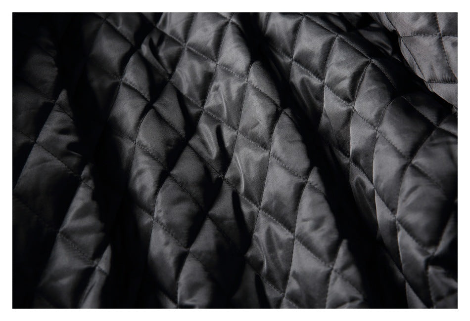 Close-up of the jacket's black satin-like quilted lining with diamond stitching.