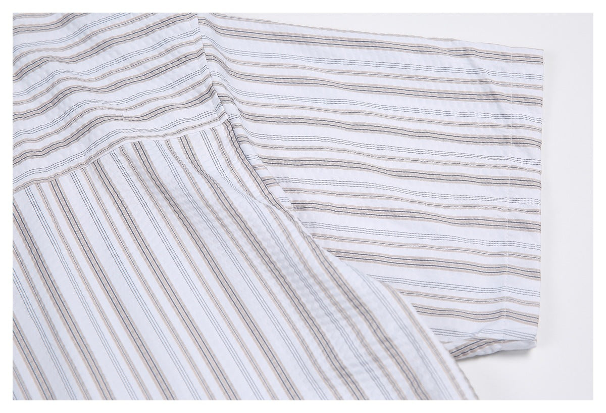 Close-up of a white striped shirt sleeve and cuff, showing contrasting stripe directions.