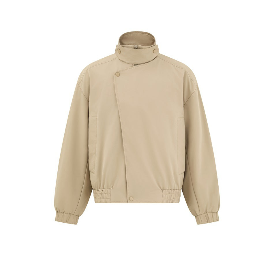 Front view of a beige high-collar jacket with an asymmetrical snap-front closure, side pockets and gathered cuffs and hem.