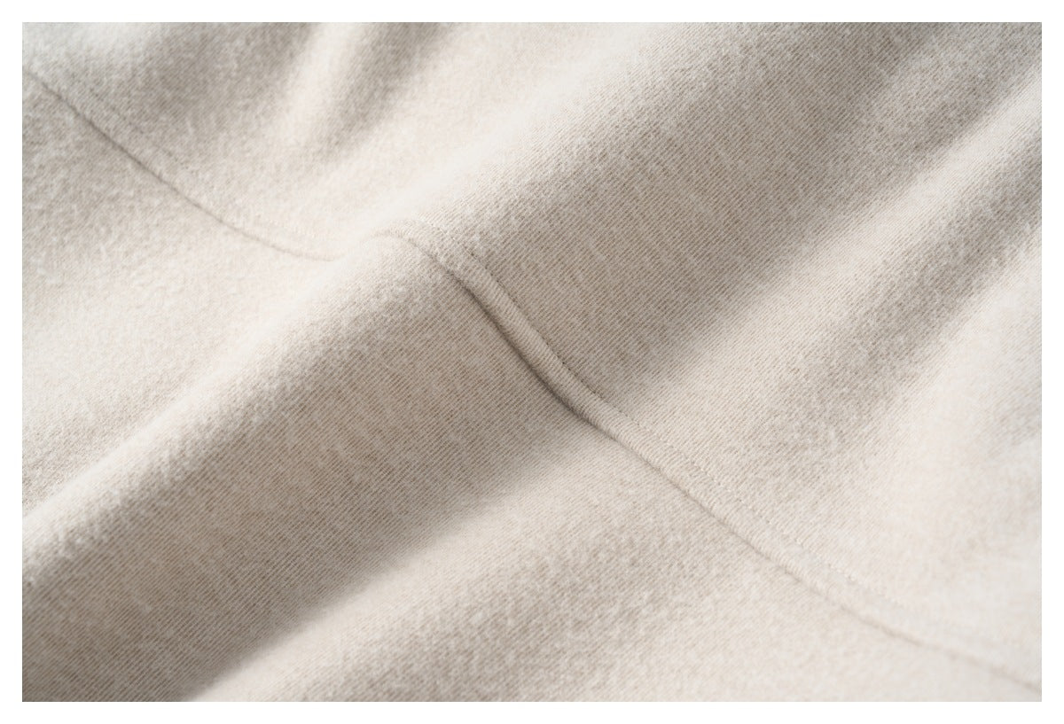 Close-up of a diagonal stitched seam on light beige fabric.