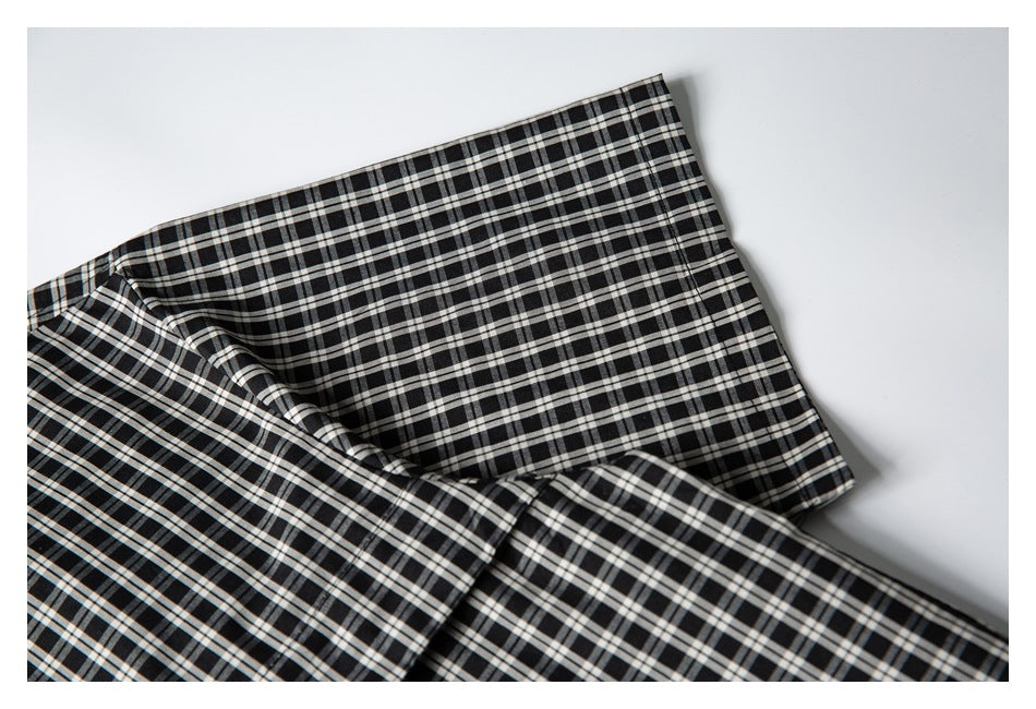 Close-up of the black-and-white checked shirt collar and overlapping fabric.