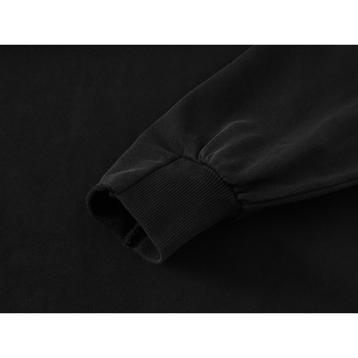 Close-up of a black sweatshirt sleeve ending in a ribbed cuff.