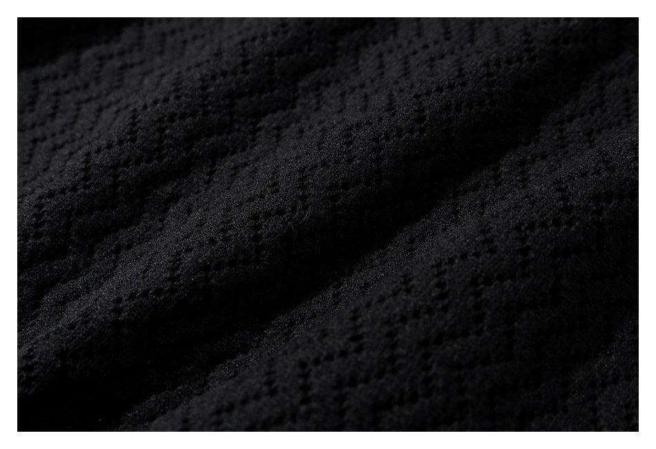 Extreme close-up showing the raised geometric texture of black knit fabric.