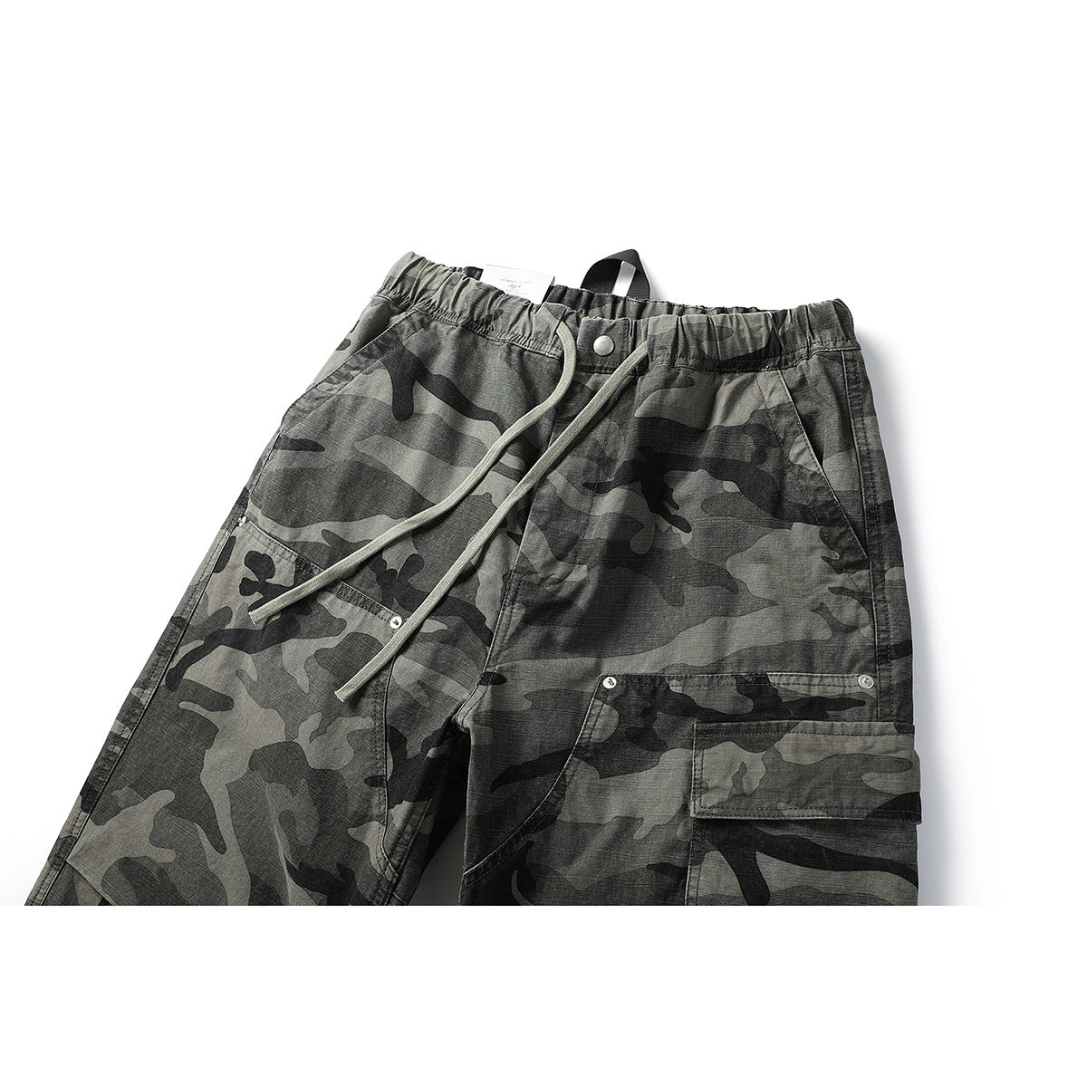 Close view of gray and black camouflage cargo pants with an elastic waist, drawstrings, and a flap pocket.