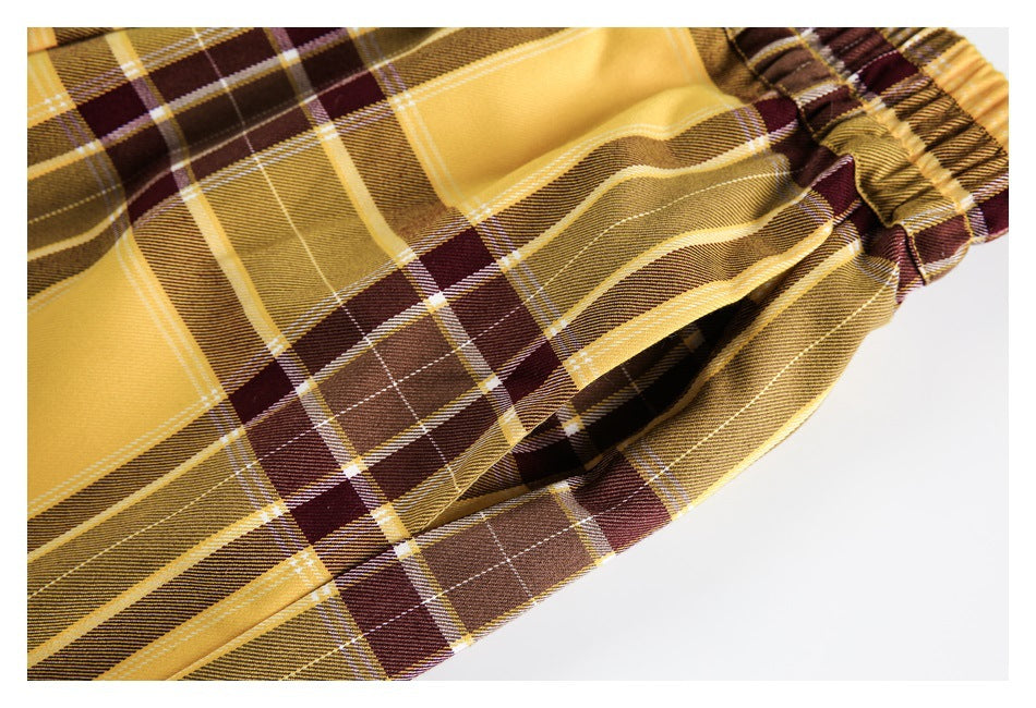 Close-up of mustard, brown and burgundy plaid fabric beside a gathered elastic edge.
