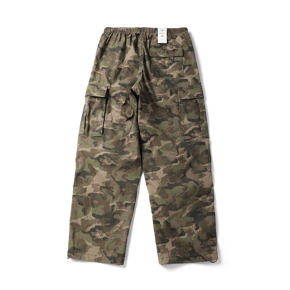 Back view of brown and olive camouflage cargo pants with flap back pocket, side cargo pockets and hang tag