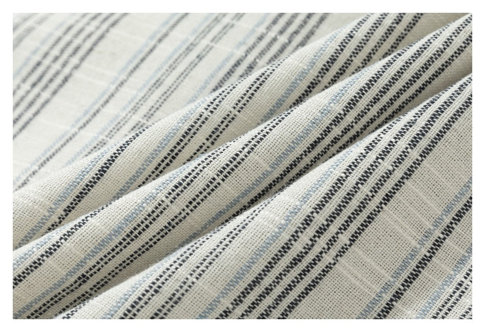 Close-up of the cream fabric's woven texture and black and pale blue striped pattern.