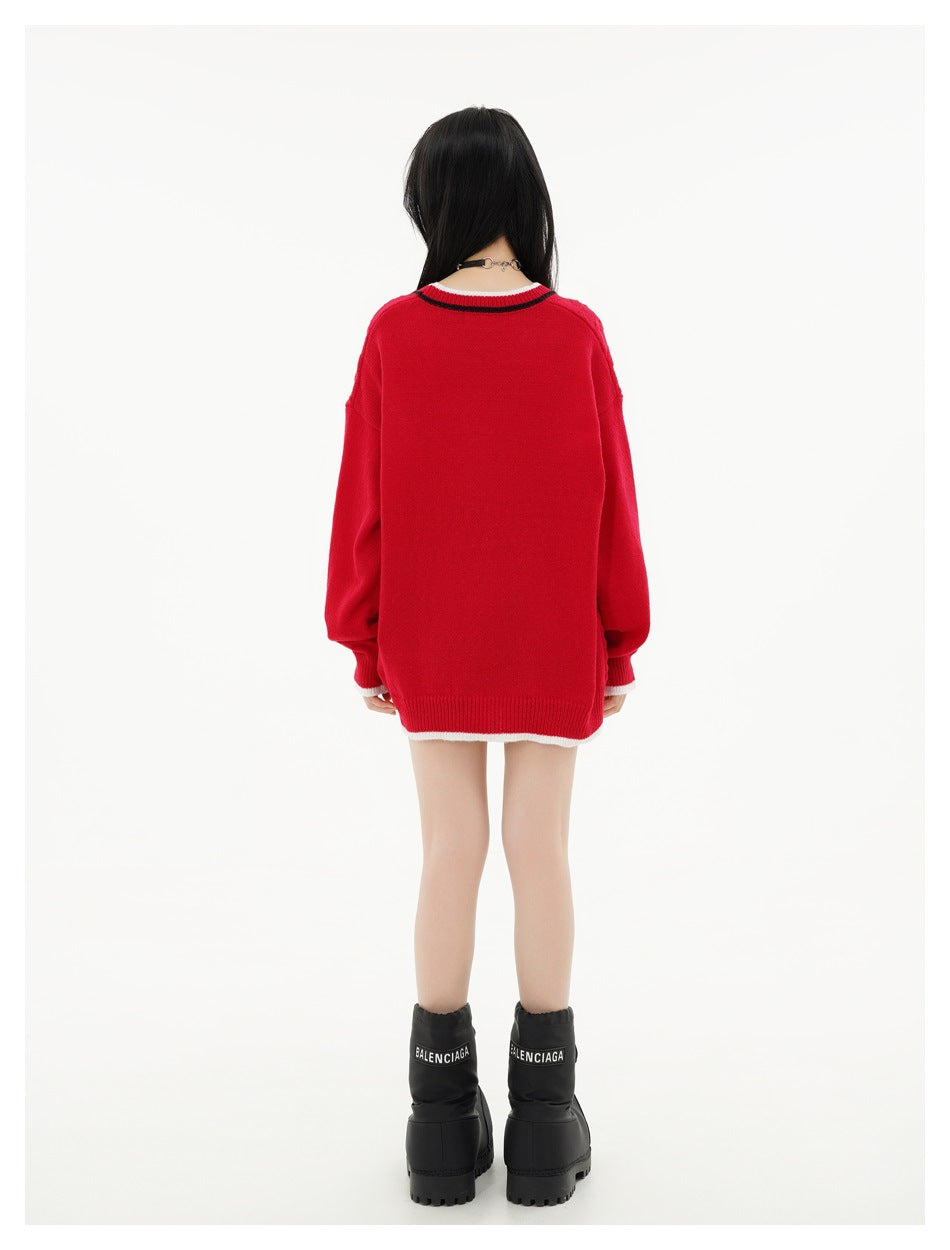 Back view of a model wearing a plain red cardigan with striped collar trim and white accents at the cuffs and hem.