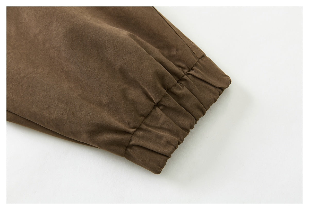 Close-up of a brown jacket sleeve ending in a gathered elastic cuff.