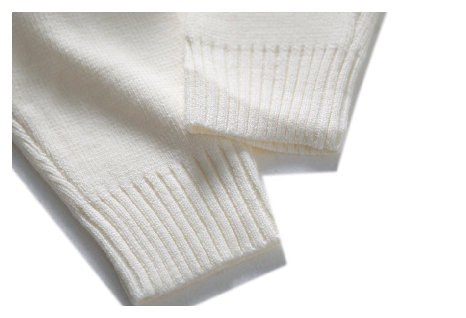 Close-up of two ribbed cuffs on an ivory knit sweater.