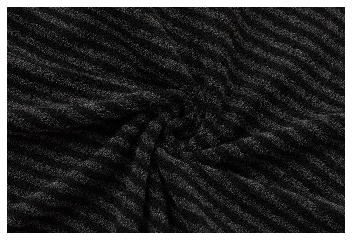 Close-up of black and charcoal textured fabric gathered into radiating folds.