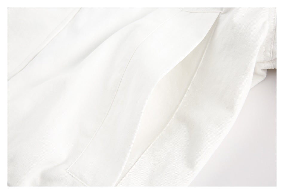 Close-up of a white garment's stitched pocket opening and adjacent seam.