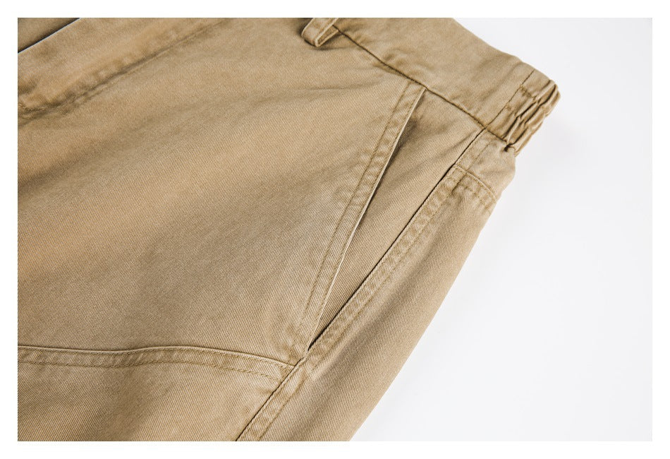 Close-up of tan pants showing a side pocket opening, belt loop, and stitched seams.