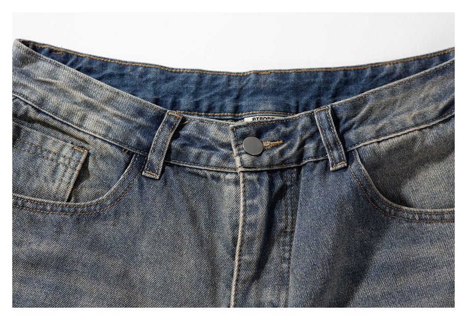 Close-up of the denim shorts' front waistband, button, belt loops and pocket openings.