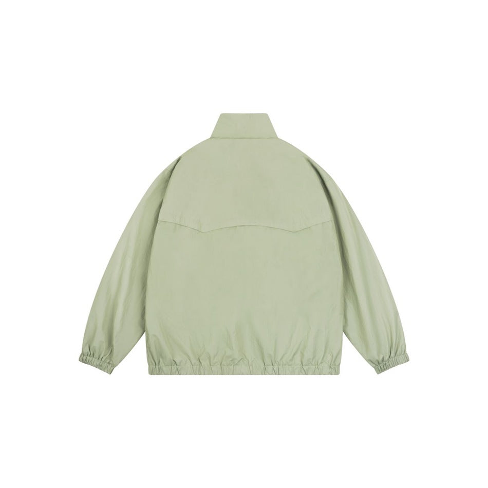 Back view of a pale sage-green stand-collar jacket with a curved upper-back seam and elasticated cuffs and hem.
