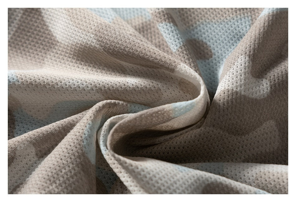 Close-up of folded beige-gray mesh fabric with a small perforated texture.