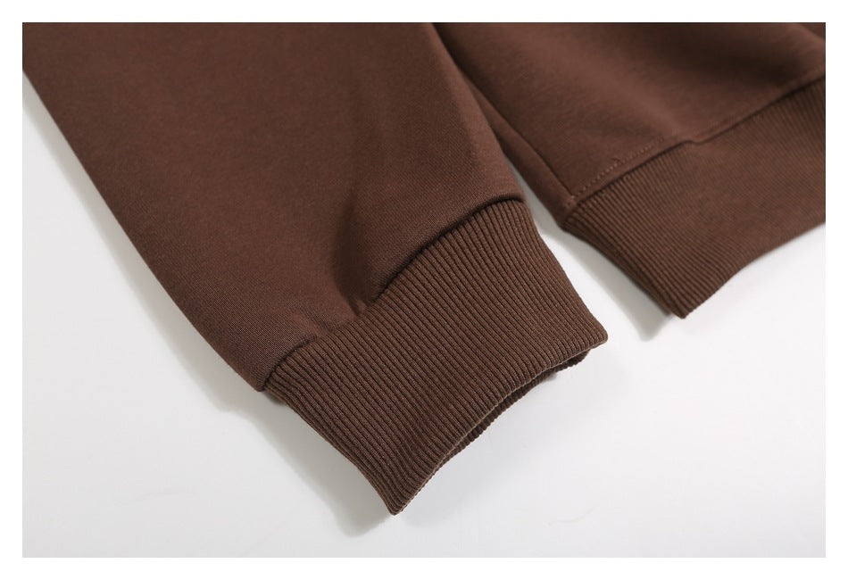 Close-up of brown garment sleeves with ribbed cuffs and stitched hems.