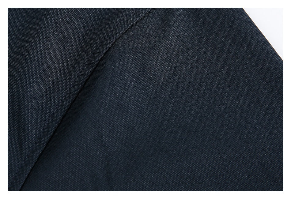 Extreme close-up of dark navy jacket fabric and a curved stitched seam.