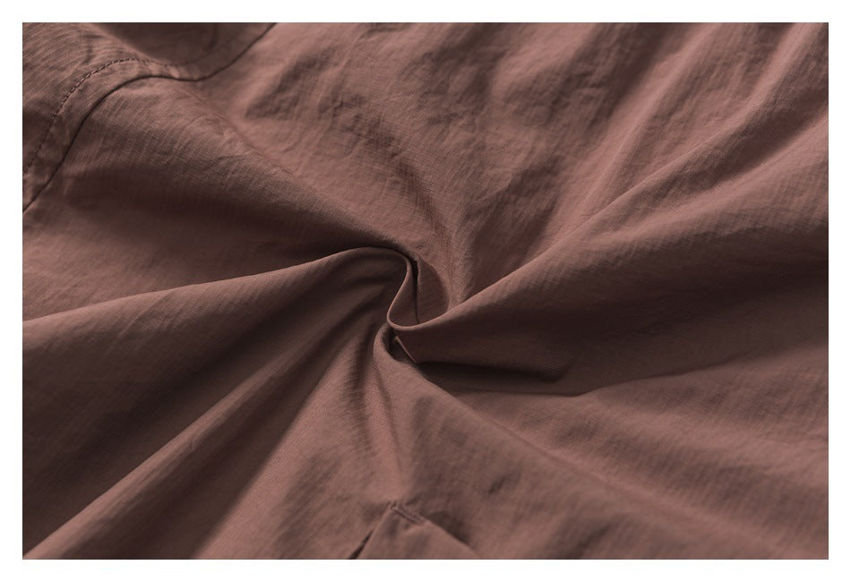 Close-up of softly gathered mauve-brown garment fabric and its fine texture.