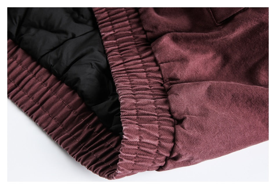 Close-up of a burgundy garment's gathered elastic waistband and black inner lining.