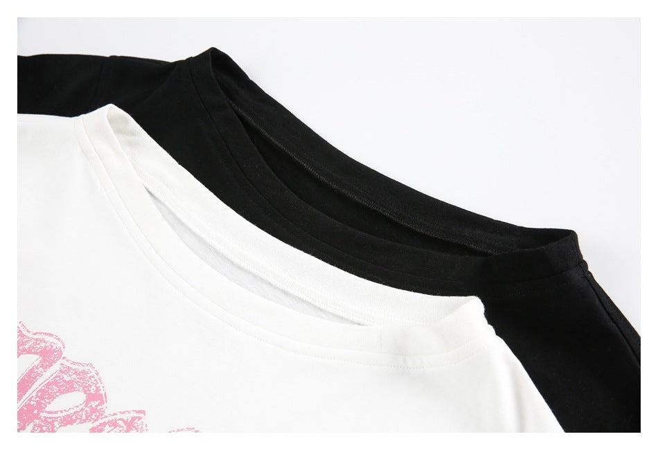 Close-up of the necklines of white and black T-shirts, with part of a pink chest graphic visible on the white shirt.