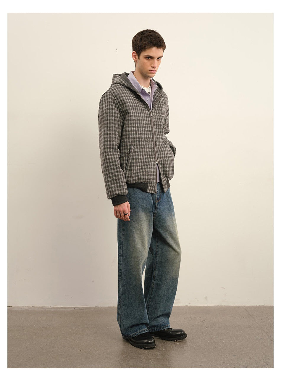 Three-quarter view of a model in a gray checkered zip-up hooded jacket with dark cuffs and hem.