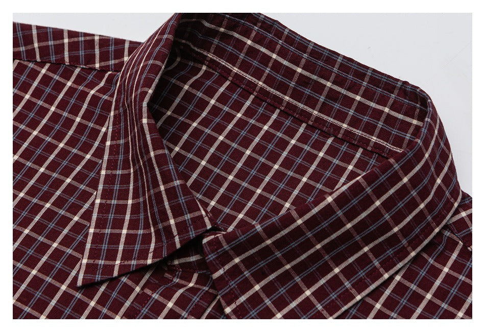 Close-up of a pointed collar on a burgundy shirt with cream and blue plaid.