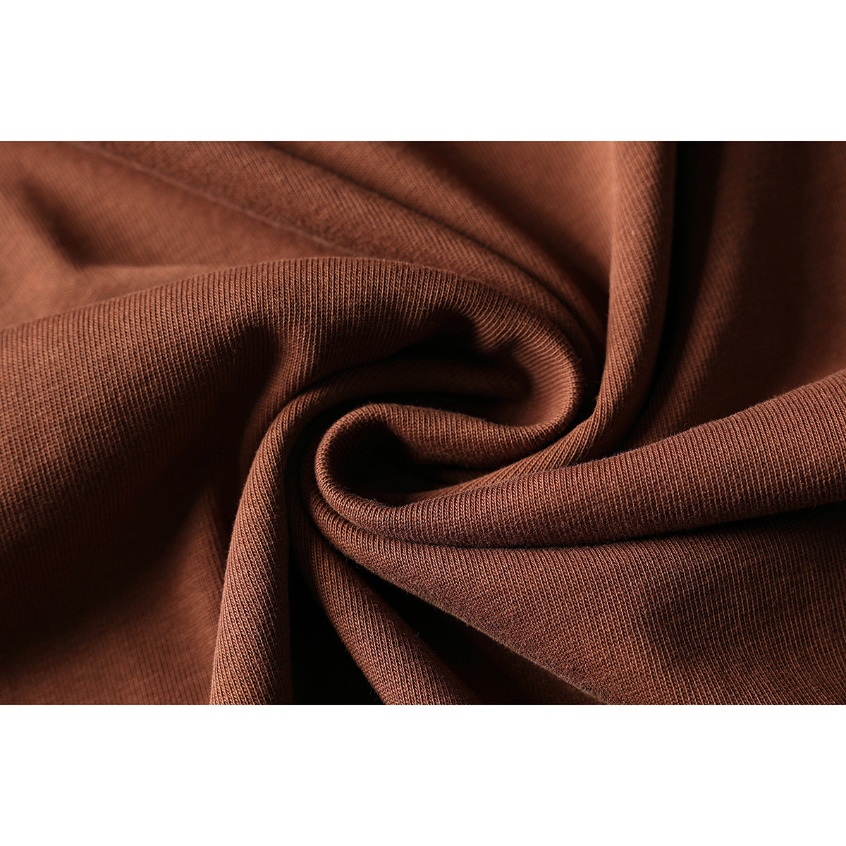 Close-up of rust-brown fabric gathered into folds, showing its fine knit texture.
