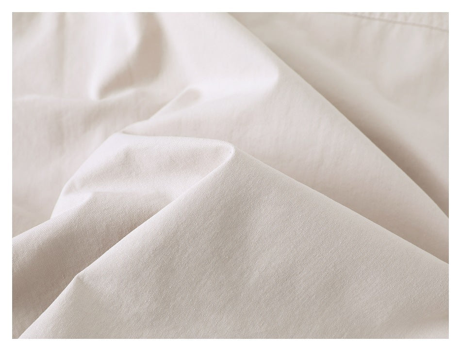 Close-up of the beige jacket fabric, showing its surface and folds.