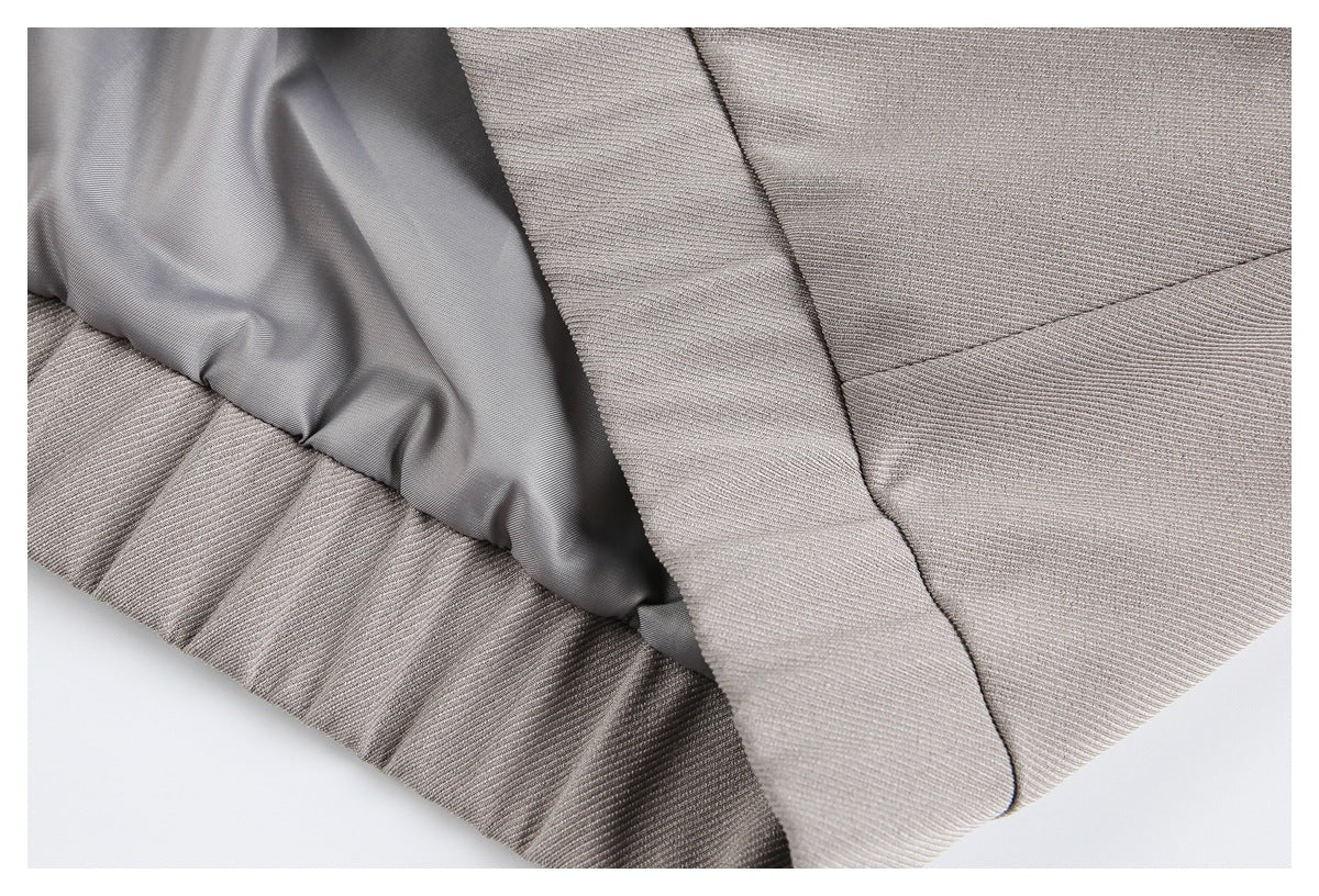 Close-up of the taupe-gray coat's interior lining, seam, and folded outer fabric.