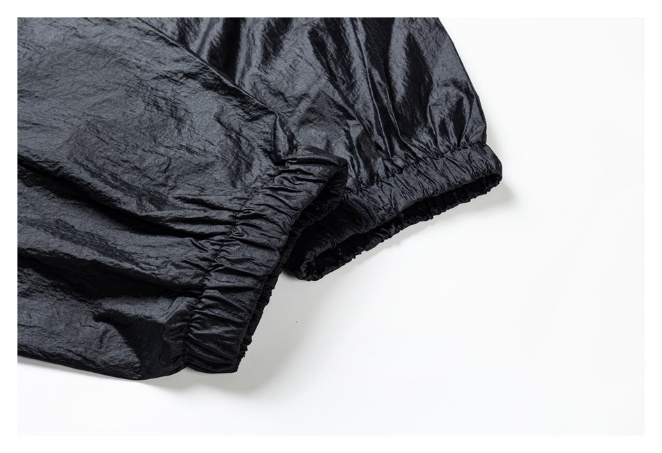 Close-up of the black jacket's gathered elastic cuffs and crinkled fabric.