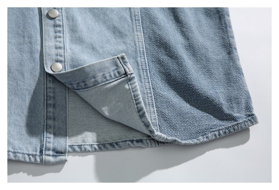 Close-up of the denim garment's button placket, patterned side panel, and partially lifted hem.