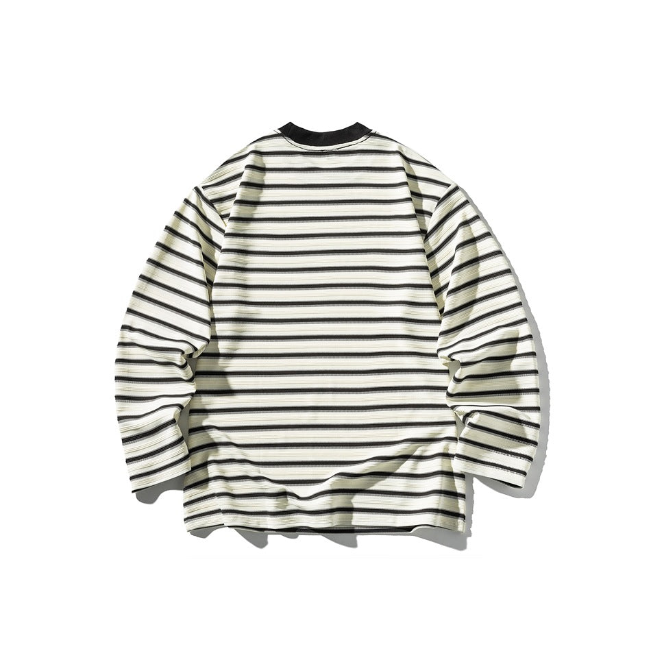 Flat lay of a long-sleeve shirt with cream, gray, and black horizontal stripes and a black collar.