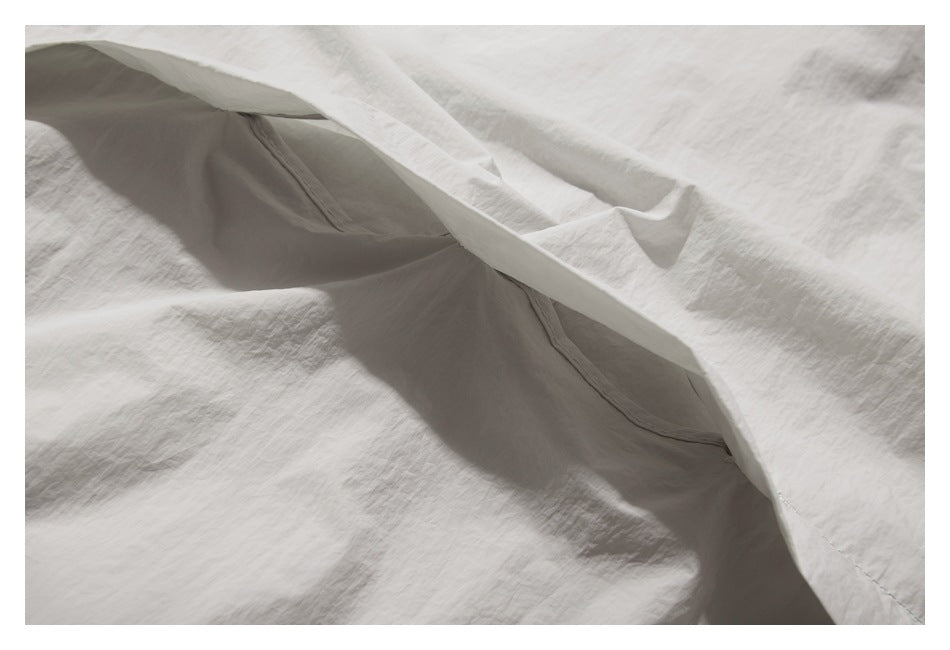 Close-up of the inside of a pale gray garment, showing a seam and pocket opening.