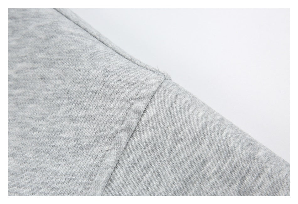 Close-up of the light gray hoodie’s sleeve seam and stitching.
