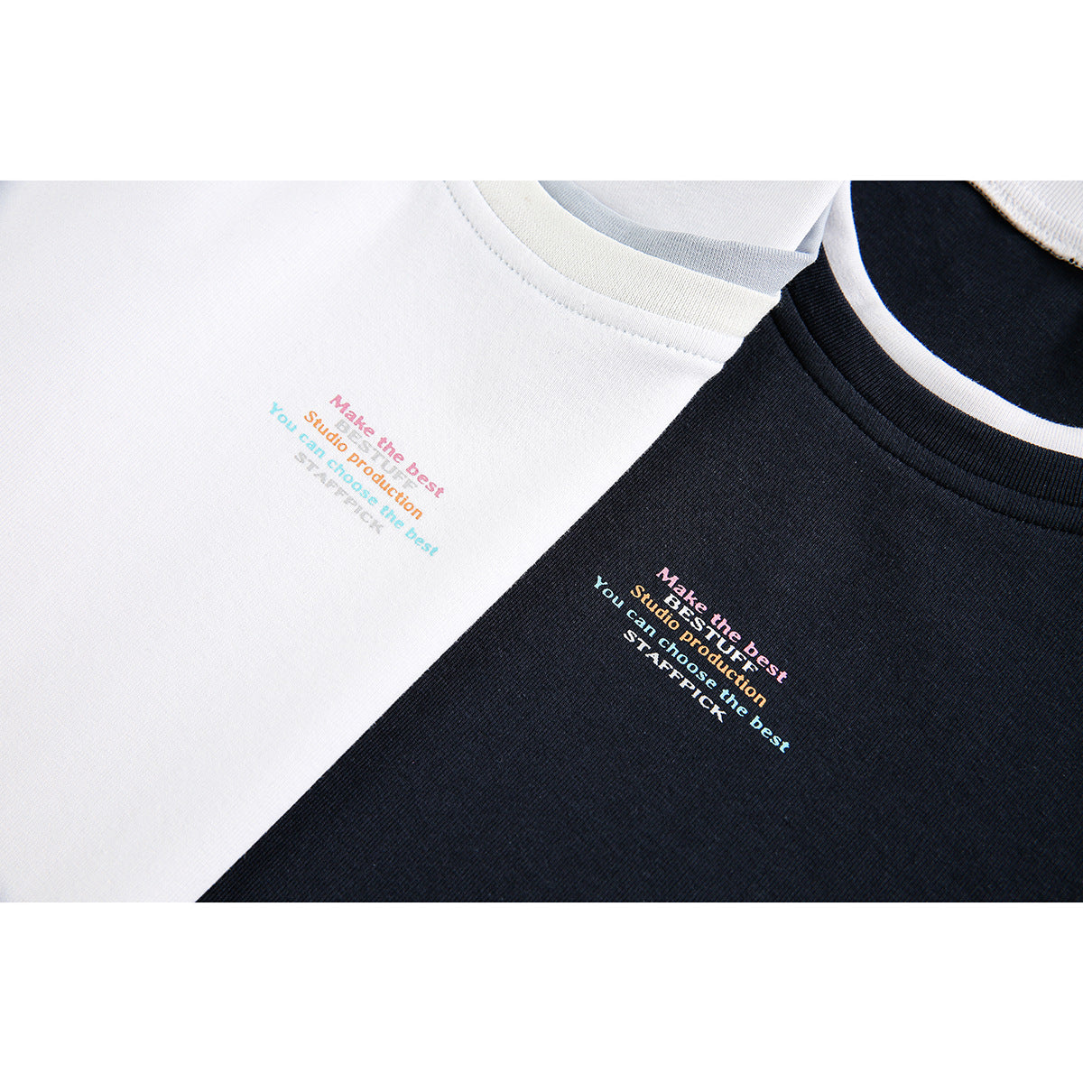 Close-up of white and black T-shirt chest areas with small multicolored English text and contrasting crew necks.