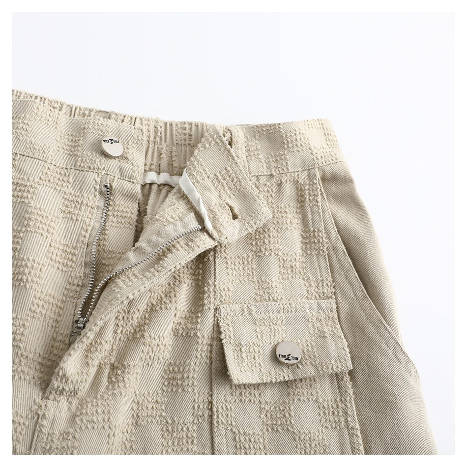Close-up of the trousers' opened front zipper and waistband, with a flap cargo pocket visible.