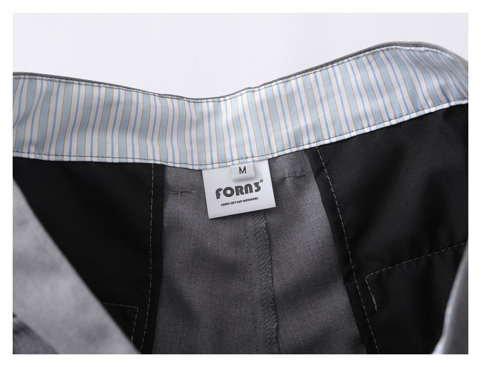 Close-up of the striped inner waistband and a sewn size M brand label inside gray shorts.