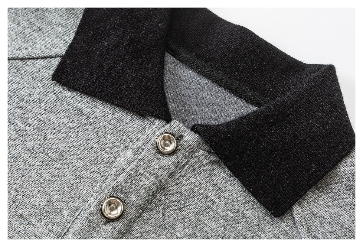 Close-up of a heather gray knit garment with a black collar and two metal buttons.
