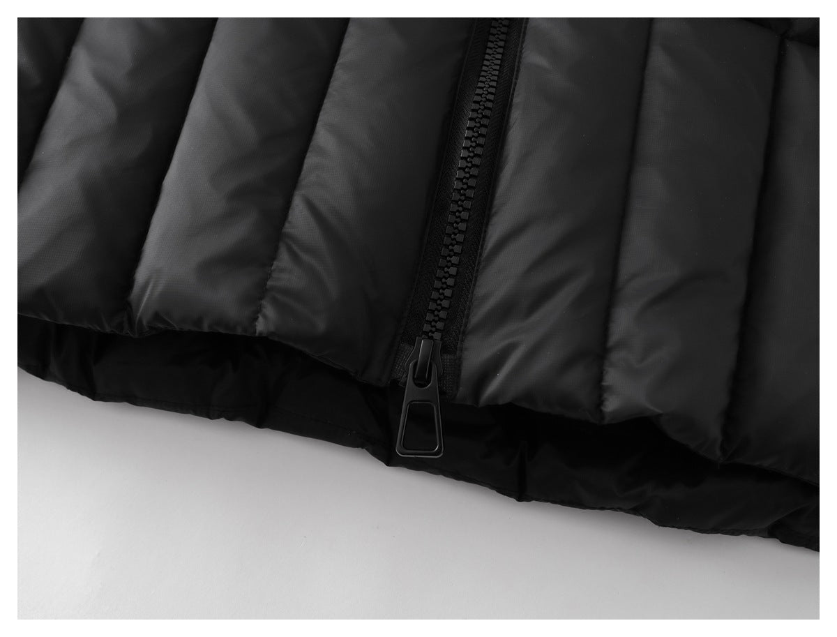 Close-up of the black puffer jacket's lower hem and large center zipper pull.