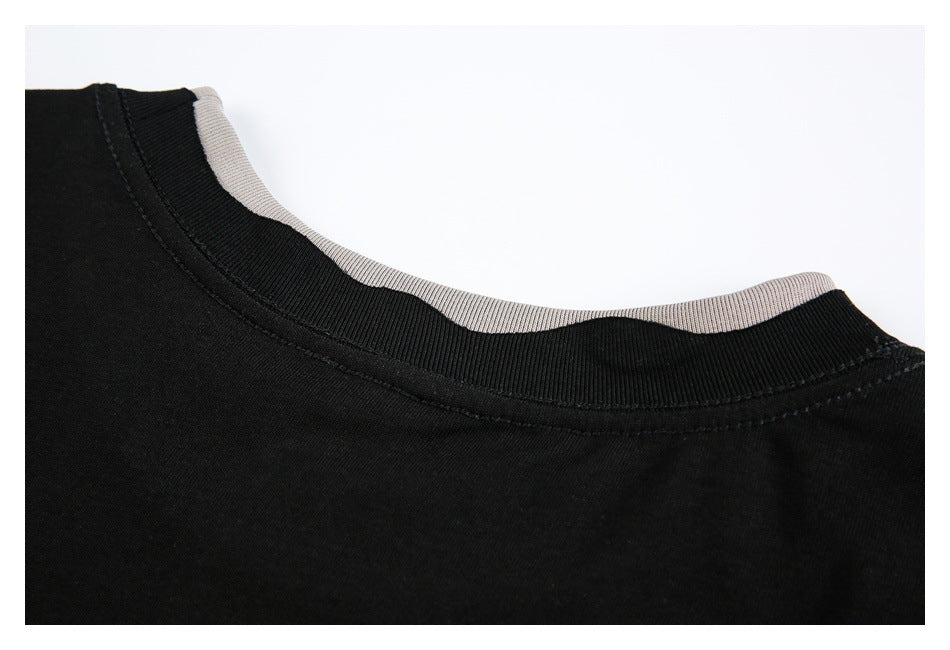 Close-up of a black ribbed crew neckline with a light-colored inner neck band.