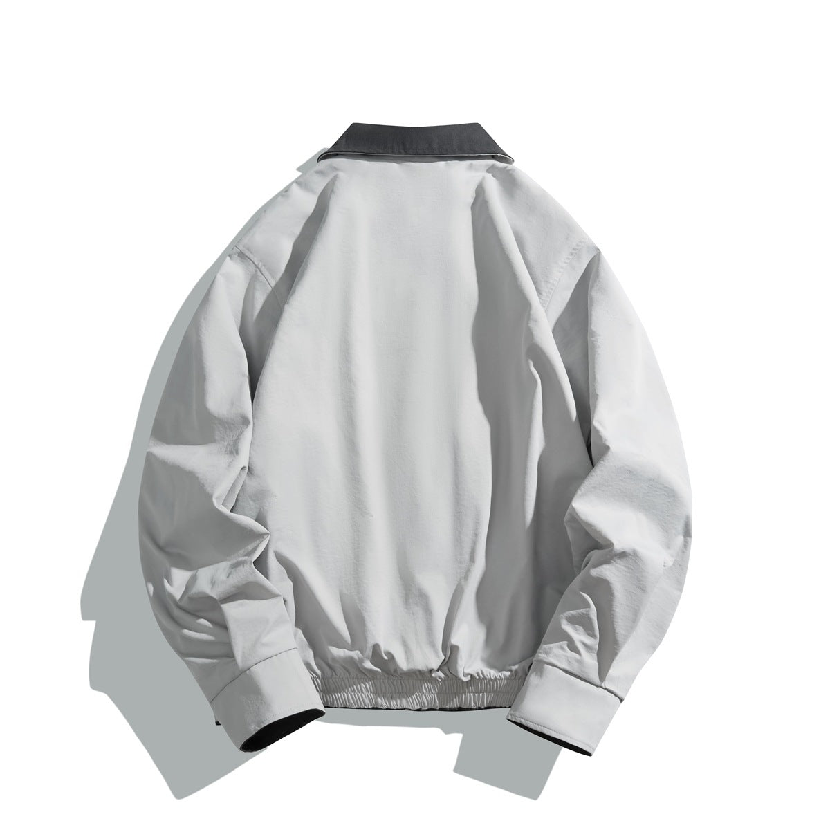 Back view of a light gray jacket with a charcoal collar, long sleeves, and an elasticized hem.