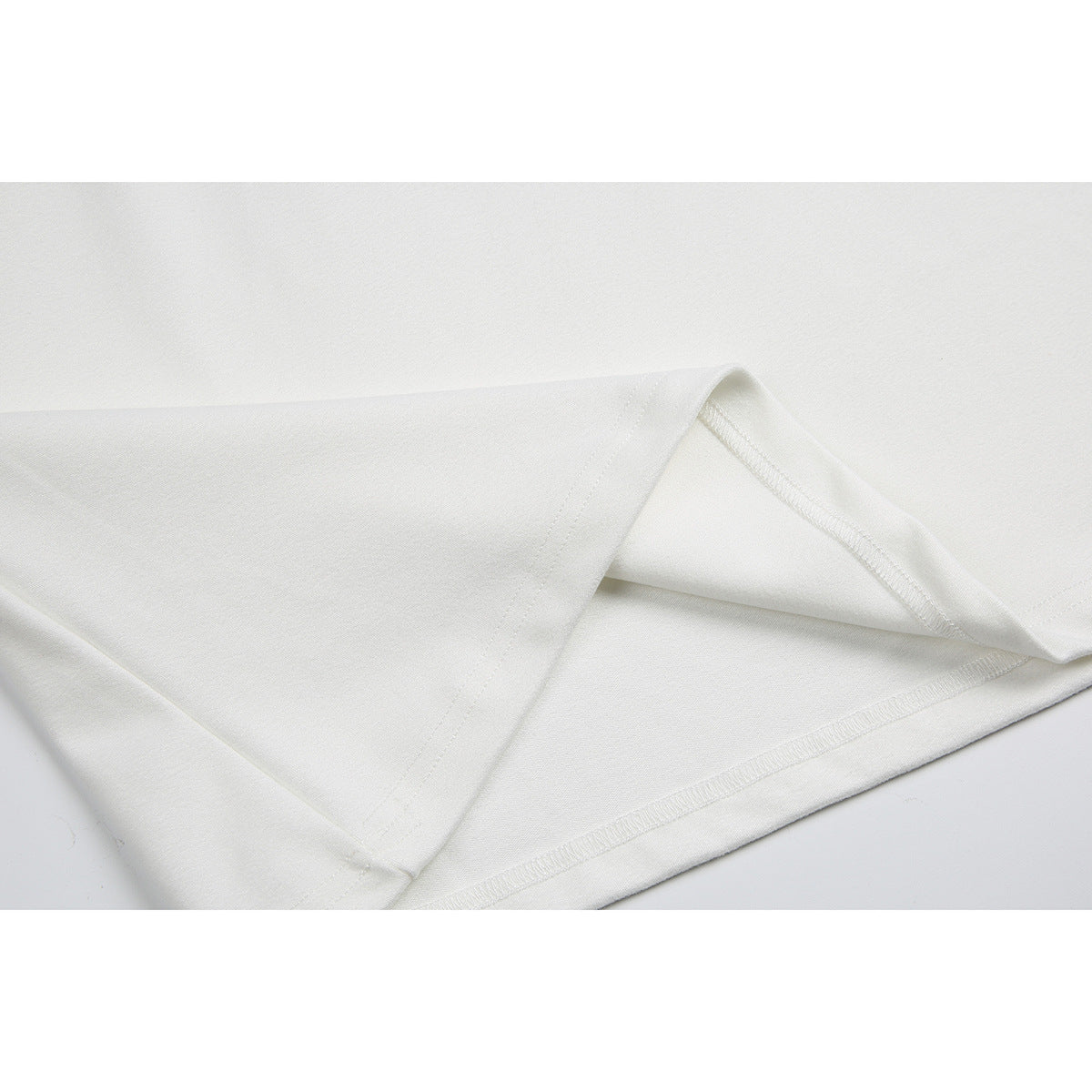 Close-up of the white shirt's lower hem and stitching.