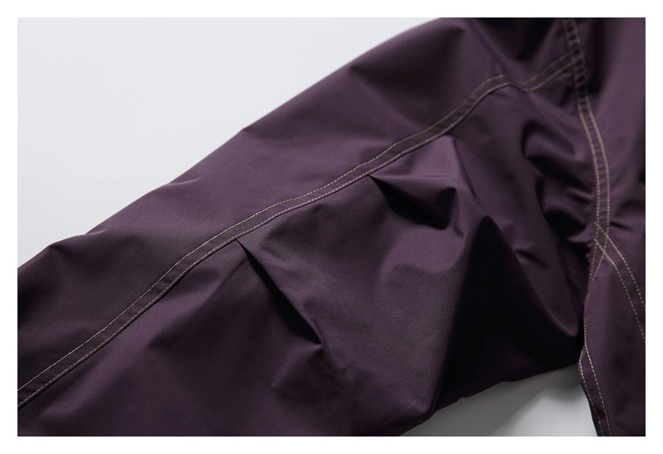 Close-up of a dark plum garment's stitched panel seam and folded fabric.